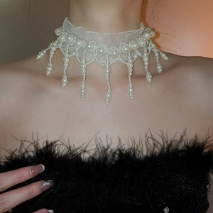 Detail of elegant white mesh choker featuring cascading pearl tassels on lace base