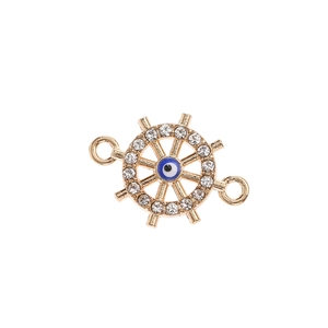 Detailed close-up of golden ship wheel charm with blue evil eye and sparkling rhinestones