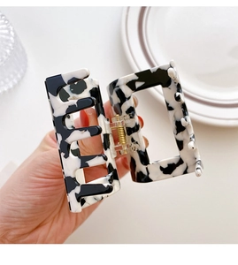 Detail of rectangular marble pattern acetate hair claw clip with metal spring mechanism