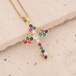 18K gold plated cross pendant necklace with multi-colored zirconia stones on stone background