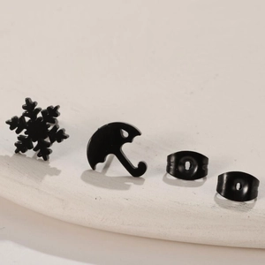 Black stainless steel asymmetric earring set featuring snowflake and umbrella stud designs