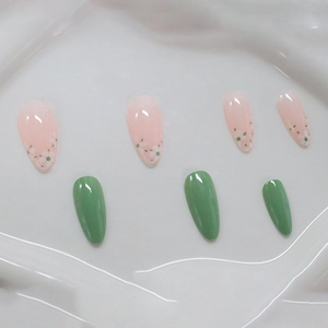 Almond press-on nails featuring minimalist green finish and white daisy floral patterns