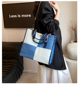 Détail du sac cabas en denim à damier bleu et blanc avec finitions dorées et bandoulière