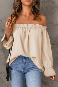 Détail de la blouse en mousseline beige à épaules dénudées et col volanté à manches