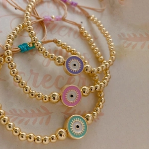 Close-up of three handmade beaded evil eye bracelets with colorful adjustable braided cords
