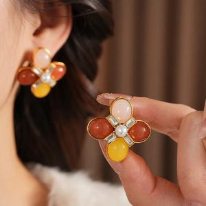 Détail de boucle d'oreille fleur vintage avec gemmes colorées et perle sur base dorée