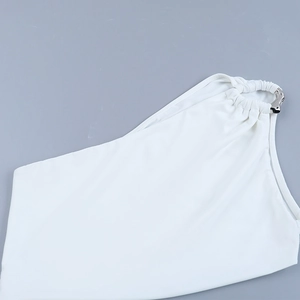 Detailed view of white one-shoulder dress with a polished silver metal ring ornament
