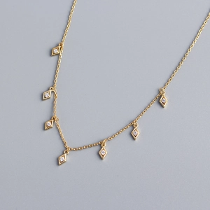 Macro shot of s925 silver tassel necklace with golden rhombic zircon pendant details