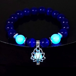 Luminous lotus flower pendant charm bracelet with glowing blue beads in a dark setting
