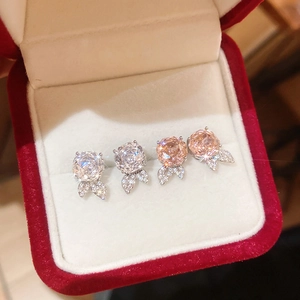 Detailansicht von Blumen-Ohrsteckern in Silber und Roségold mit funkelndem Zirkon