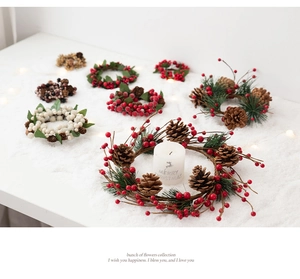 Detailed view of Christmas candle rings with red berries, pine cones and festive greenery