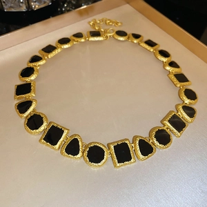 Detail of vintage geometric necklace with gold textured edges and black square stones