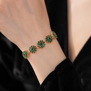 Close-up of vintage flower bracelet with gold petals and green zircon marquise stones