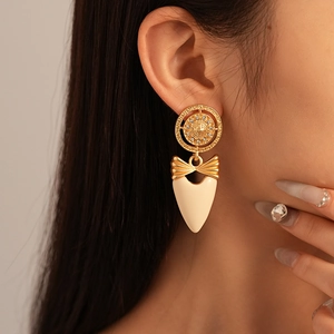 Détail de boucles d'oreilles cœur vintage avec nœud et cristaux sur un mannequin