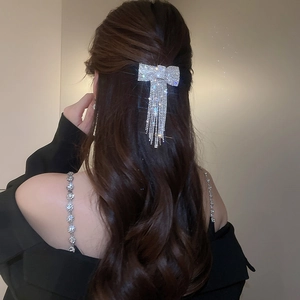 Pince à cheveux nœud argenté avec pompons et strass pour une coiffure élégante