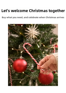 Close-up of red and white striped candy cane ornament held against a Christmas tree