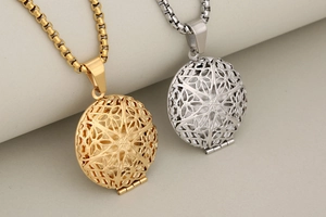 Detail of round hollow locket pendants in gold and silver finish with geometric patterns