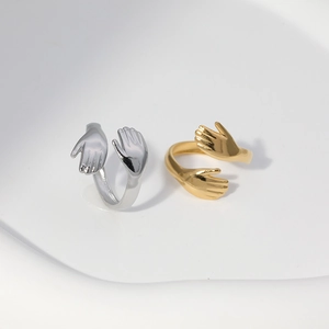 Close-up of adjustable hug-shaped rings in polished gold and silver stainless steel