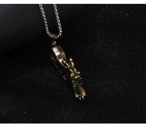 Close-up of vintage bronze motor pendant with silver box chain on black glitter background