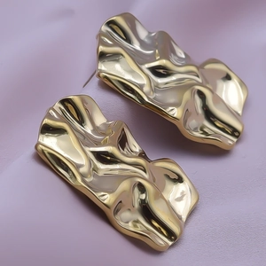 Detailed view of 18k gold plated stainless steel earrings with irregular wrinkled texture