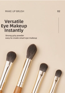 Detail of four professional eye makeup brushes with matte gold ferrule and soft bristles