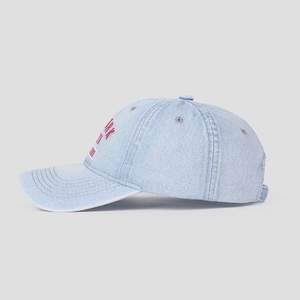 Close-up of light blue washed denim baseball cap with pink New York embroidery details