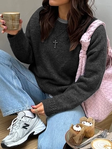 Minimalist dark grey crew neck long sleeve sweater with a pink woven shoulder bag for women