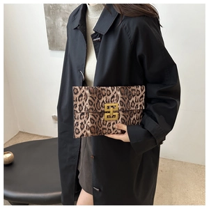 Detail of leopard print envelope clutch featuring a prominent gold H-shaped metal buckle