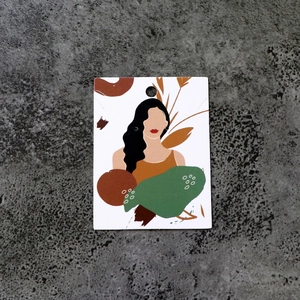 Macro view of paper jewelry display card with artistic female portrait and pre-cut holes