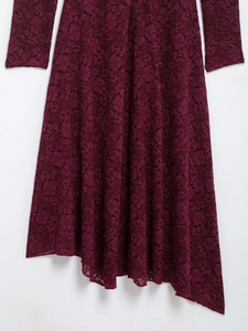 Detail of wine red lace dress showing intricate floral patterns and irregular hemline