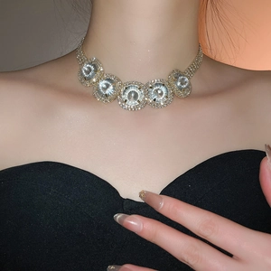 Close-up of luxury round diamond necklace with five large crystals on a model