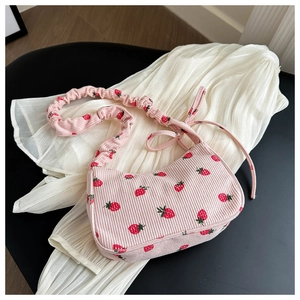 Close-up of pink corduroy shoulder bag with strawberry print and ruched strap details