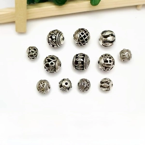 Detailed view of hollow alloy spacer beads with ethnic carvings and silver finish