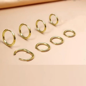 Macro view of minimalist gold stainless steel hoop earrings in various diameters