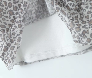 Detail von Mesh-Stoff mit Leopardenmuster, weißem Futter und hochwertiger Overlock-Naht