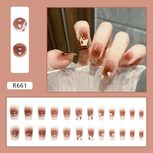 Caramel amber press-on nails with heart patterns and cow print in coffin shape