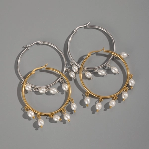 Detailed view of elegant gold and silver hoop earrings featuring hanging pearl tassels