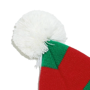 Détail du bonnet de Noël tricoté à rayures rouges et vertes avec pompon blanc