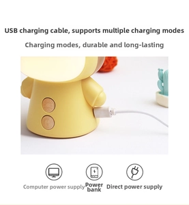 Detailed view of yellow cartoon LED lamp with USB charging port and dual adjustment buttons