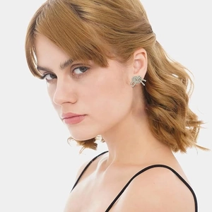 Close-up of a model wearing minimalist silver and gold knotted stud earrings