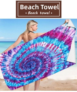 Vibrant colorful spiral tie-dye microfiber beach towel held by model at the seaside
