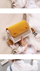 Detail of trendy color-block crossbody bag with festive embroidered wide shoulder strap