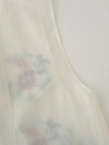 Gros plan sur un tissu en maille blanche semi-transparente avec imprimé floral délicat