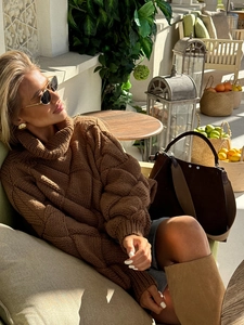Close-up of thick brown turtleneck sweater featuring classic coarse cable knit texture