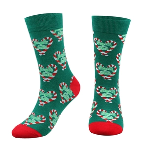Detail of green cotton Christmas socks with Jingle Balls text and candy cane heart pattern