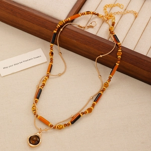 Detail of vintage layered tiger eye stone bead necklace with polished golden alloy beads
