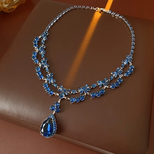 Macro shot of luxury blue teardrop zircon pendant and sapphire-colored crystal necklace
