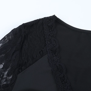 Detailed close-up of intricate lace patchwork and V-neck stitching on black long sleeve top