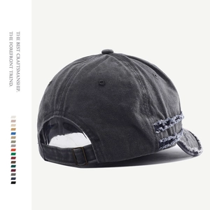Detail of adjustable metal buckle and distressed frayed edges on washed cotton baseball cap