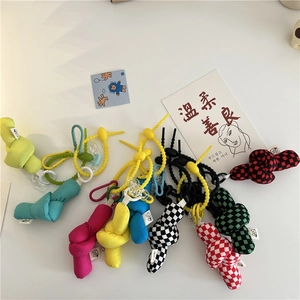 Flat lay of colorful stuffed fabric knot charms with plaid patterns and plastic clips